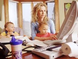 A young woman with a child next to her blogging on a computer