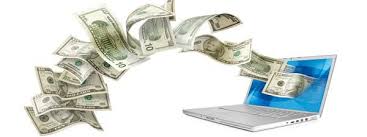 Dollar bills falling on a laptop.